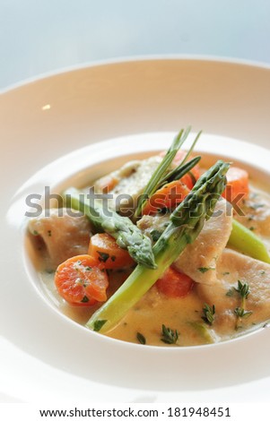 Slow cooked veal in milk. veal in milk braised veal in milk sauce with asparagus, carrots and herbs on white plate, diet, fitness menu, dish for dinner