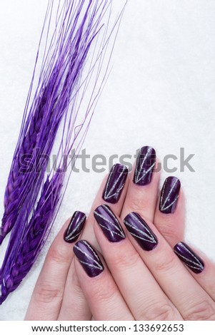 Beautiful hands with purple manicure and flower