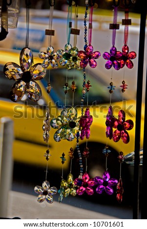 Hanging decorations in storefront window with Taxi in background