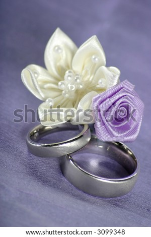 stock photo wedding bands in white gold on lavender colored background