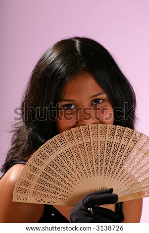 cute young woman hiding part of her face behind a fan smiling with her eyes