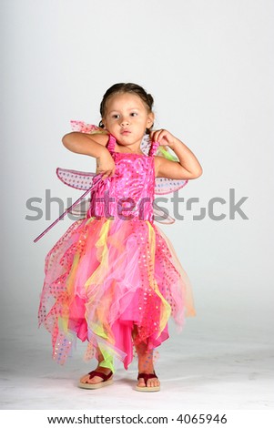 Cute toddler girl dancing in a pink fairy dress - high-key photograph