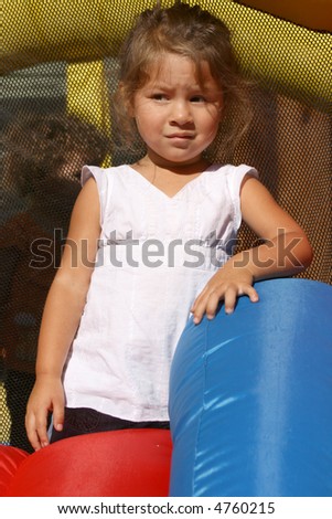 cute toddler girl posing in front of a bounce house