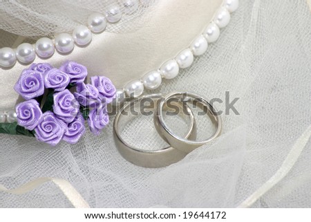 stock photo wedding bands on veil with purple flowers