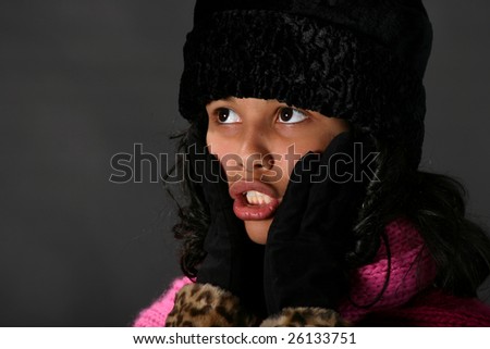 Attractive young Hispanic woman in winter outfit looking surprised