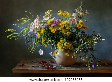 Still life with a voluptuous bunch of field flowers and red currants
