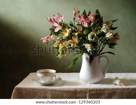 Still life with a bouquet of flowers and a cup of tea