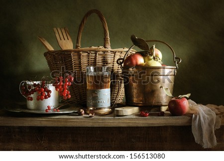 Still life with a bucket of apples and a cup of tea
