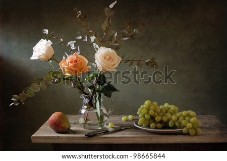 Beautiful still life with a bouquet of roses and juicy fruit
