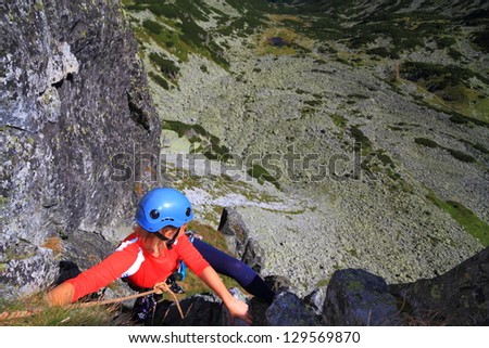 Climber on the rock wall, high above ground