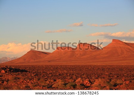 Eroded land under blue sky and white clouds at sunset, Atlas mountains, Morocco