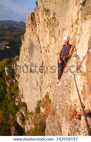 Climber on the rock route high above ground, Romania