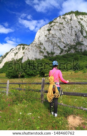 Climber woman marching to the route with the climbing gear on