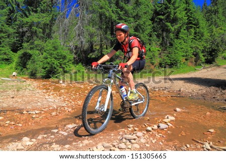 Cyclist girl on mountain bike rides outdoor road
