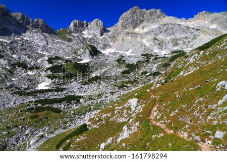 Mountain landscape with narrow trail and sunny weather