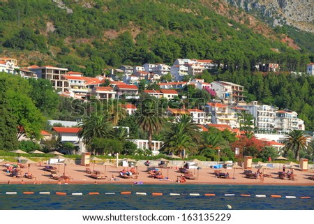 Small Mediterranean beach with people tanning and enjoying the sun