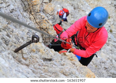 Climber on demanding section of via ferrata route, Dolomite Alps, Italy
