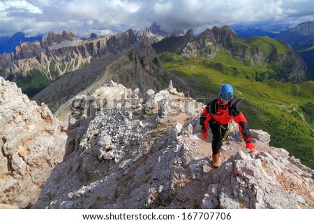 Woman climber on narrow trail to the mountain summit, Dolomite Alps, Italy
