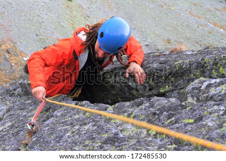 Mountaineer ascends demanding pitch on granite rock face
