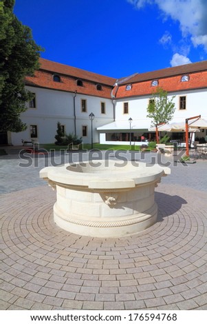 Paved square decorated with round stone well from medieval times