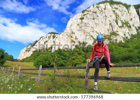 Young woman jumps wooden fence on the way to the climb wall
