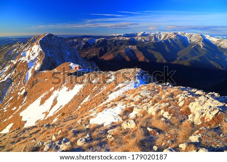 Mountain slope and small patches of snow at sunrise
