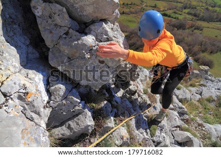 Woman grips a hold on climbing route