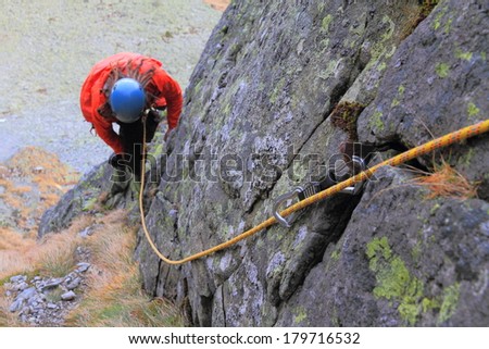 Climbing rope attached to an iron peg fit into granite crack