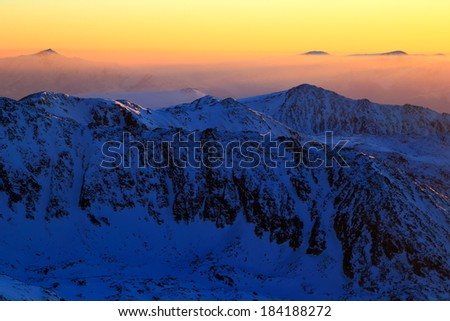 Remote mountain ridges and summits at sunset in winter