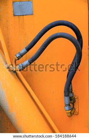Hydraulic hoses on mobile arm of a machinery
