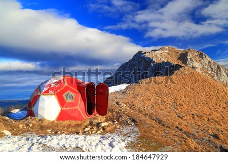 Dome shaped refuge with an open door on top of the mountain ridge