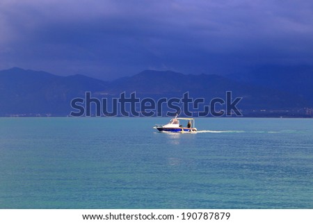 Small fishing boat speeding to the harbor before the storm begins, Greece