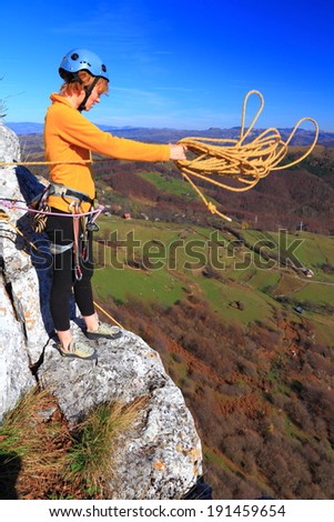 Climber woman casts the rope for abseil