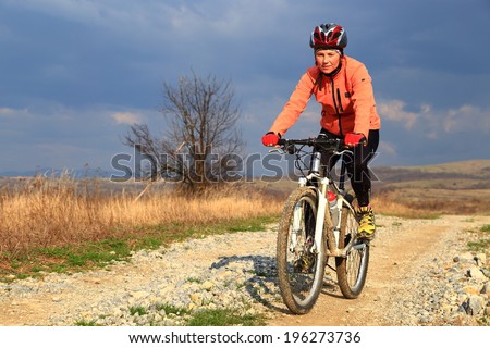 Bike ride on sunny dirt road under gloomy sky