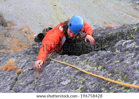 Climber removes protection gear from the piton