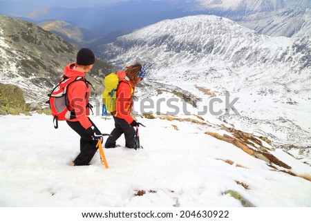 Alpine climbers down climbing a snowy slope in overcast winter day