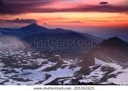 Darkness falls on snowy mountains after sunset
