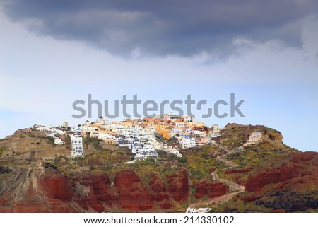 Cloudy sky above traditional village high above sea level on the island of Santorini, Greece