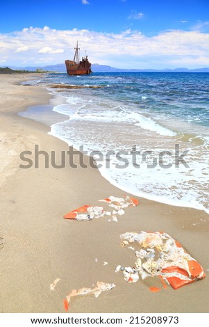 Ruins covered by sand beach with distant ship wreck near Gythio, Greece