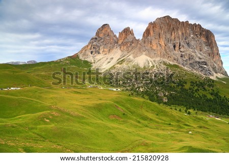 Green valley and distant massif of Sassolungo seen from Sella pass, Dolomite Alps, Italy