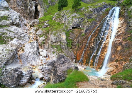 Stream of water pouring into small pond on Lasties valley, Sella massif, Dolomite Alps, Italy