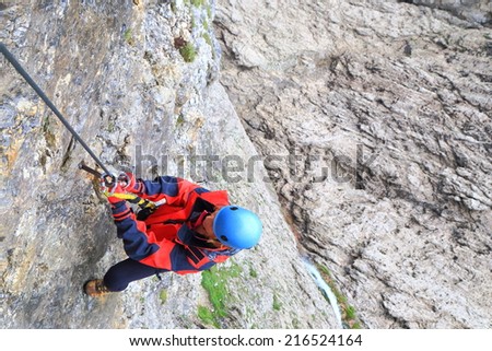 Climber woman clipping the protection gear on the cable of \