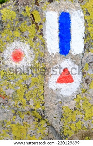 Different trail signs painted on granite rock