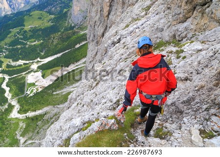 Exposed trail and climber high above ground on via ferrata \