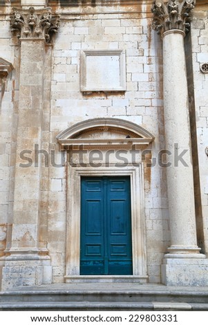 Aged door decorated with stone sculptures of a church inside old town of Dubrovnik, Croatia