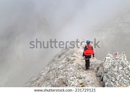 Rocky trail on top of Tofana range with via ferrata climber on \