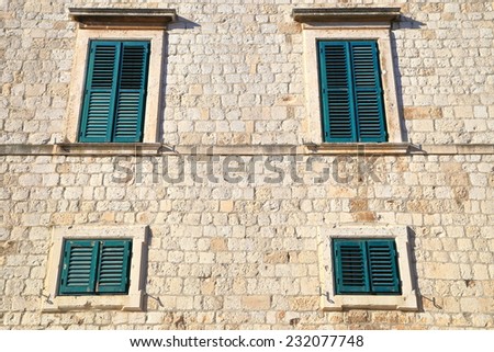 Green windows of a building with Venetian architecture inside the old town of Dubrovnik, Croatia
