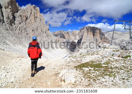 Woman climber approaching the Vajolet towers, Catinaccio massif, Dolomite Alps, Italy
