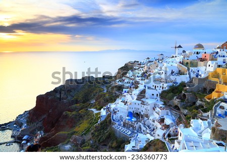 Golden clouds above the sea and white buildings at sunset, Santorini island, Greece