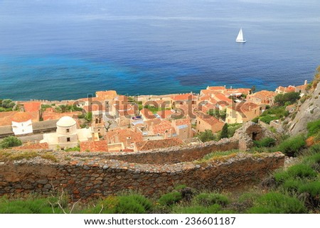 Distant sail boat passing by the Byzantine town of Monemvasia, Greece